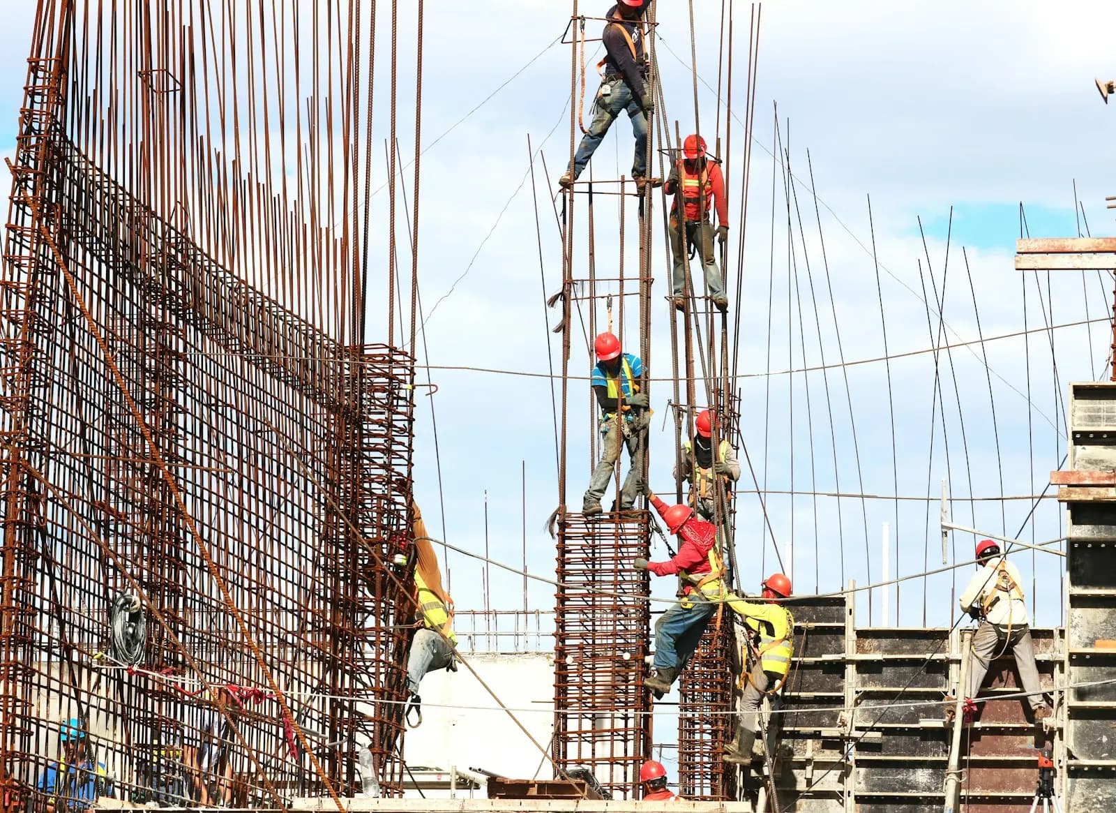 Workers fixing steel reinforcement bars for RCC columns on a construction site